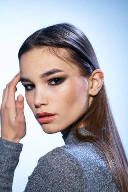 Güzel esmer, parlak makyajlı. Yakından çekici görünüyor.