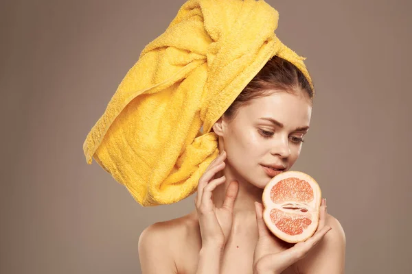 Жінка з грейпфрутом в руках голі плечі і вітаміни по догляду за шкірою — стокове фото