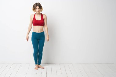 Tamamen büyümüş bir kadın parlak bir odada yoga meditasyonunda sporla meşgul.