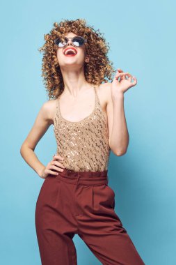 Güzel kadın kıvırcık saçlı, kırmızı dudaklı, şık elbiseli, çıplak omuzlu. 