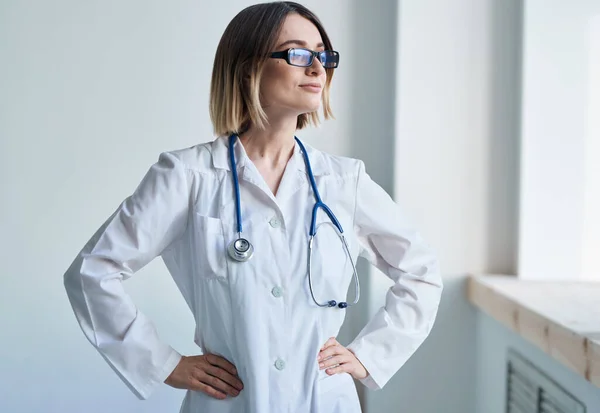 Woman with professional stethoscope Doctor in medical gown in bright room