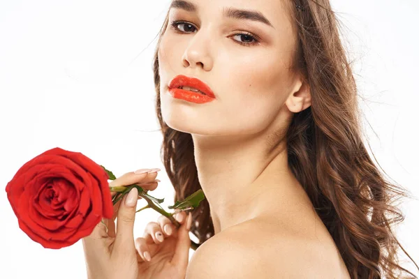 Žena s nahými rameny a červenou růží večer make-up světlo na pozadí — Stock fotografie