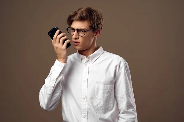 Finance guy in een shirt met een telefoon in zijn hand bedrijf — Stockfoto