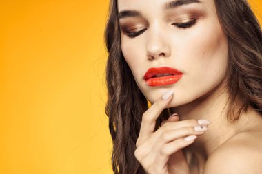 Güzel esmer kırmızı dudaklar çıplak omuzlar cilt bakımı sarı arka plan