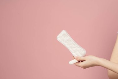 Koruyucu ped ve tampon pembe arka plan regl günlerinde kadınların elinde.