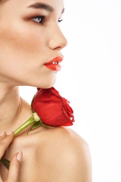 Urocza brunetka dziewczyna z makijażem na twarzy i czerwona róża w jej ręce — Zdjęcie stockowe