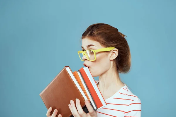 Vrouwelijke student met notitieblokken en bril kapsel op haar hoofd leraar model blauwe achtergrond — Stockfoto
