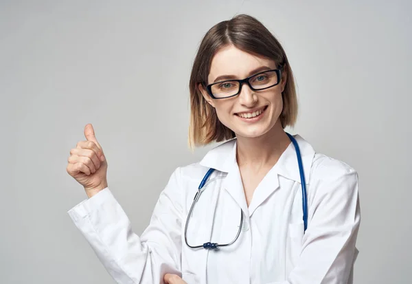 Enfermera en vestido médico gesto con las manos sobre fondo claro recortado ver —  Fotos de Stock