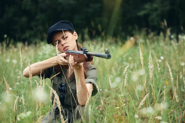 Mulher militar arma na mão é um estilo de vida de caça macacão verde — Fotografia de Stock