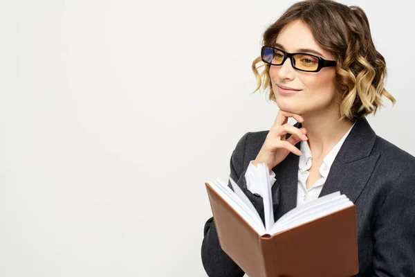 Mulher no trabalho com livro na mão luz fundo clássico terno óculos cabeça — Fotografia de Stock