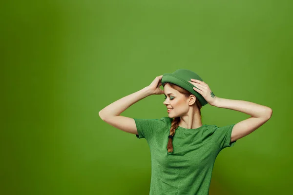 Femme heureuse avec trèfle le jour de la Saint-Patricks en vêtements verts et un chapeau sur sa tête gesticulant avec ses mains — Photo