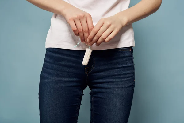 Wanita dengan tampon dan celana jeans menstruasi latar belakang biru dipangkas memandang kebersihan — Stok Foto