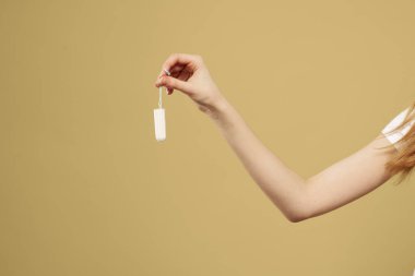 Elinde bir tampon olan bir kız. Regl döneminin kritik günlerinin görüntüsü kadar.