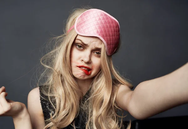 一个喝醉了的金发姑娘，头上戴着粉色的睡眠面具，脸上涂了口红 — 图库照片