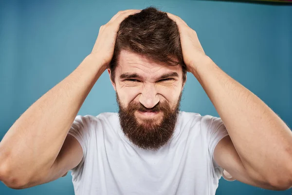 Baard man ontevreden gezicht expressie emoties close-up blauw achtergrond wit t-shirt — Stockfoto
