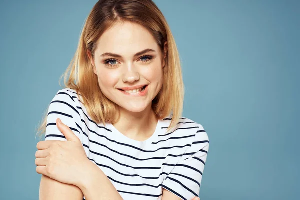 Blond meisje in gestreept t-shirt lifestyle blauw achtergrond plezier — Stockfoto