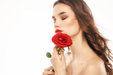 Çıplak omuzlu ve kırmızı gül makyajlı bir kadın.