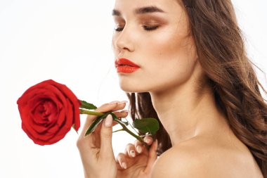 Çıplak omuzlu ve kırmızı gül makyajlı bir kadın.