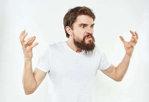 Ein emotionaler Mann auf hellem Hintergrund gestikuliert mit den Händen. — Stockfoto