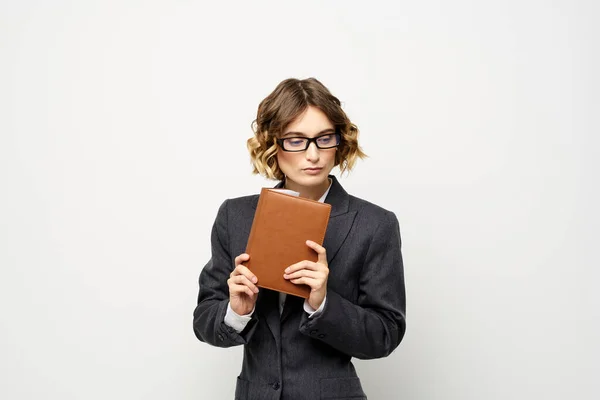 Ділова жінка з блокнотом і окулярами працює на світлому фоні обрізаний вид на модель костюма . — стокове фото
