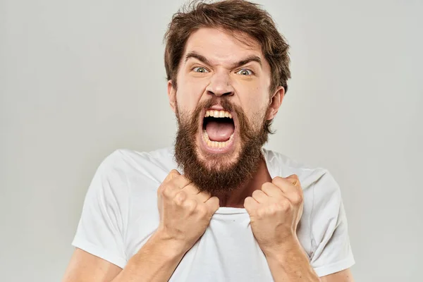 Чоловік в білій футболці емоції вирази жест з руками обрізаний вид світлого фону — стокове фото