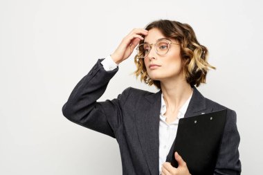 İş elbiseli kadın, iş belgelerini, gözlükleri, saç stilini finanse ediyor.