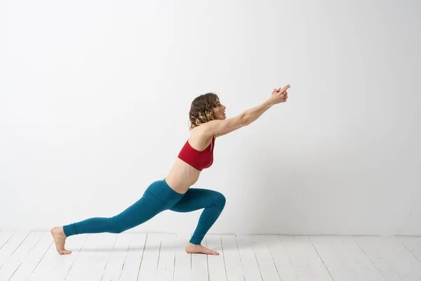 Kvinna i leggings är engagerad i gymnastik i ett ljust rum smal figur fitness sport — Stockfoto