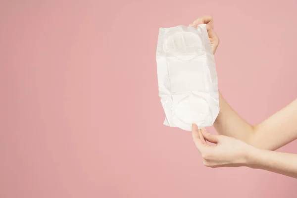 Női kezekben lévő csomagolásban, rózsaszín háttér vágott nézet higiénia tiszta megjelenés — Stock Fotó