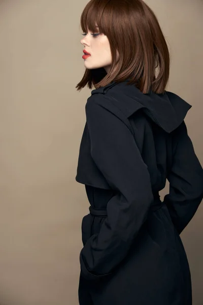 웃는 사진관에 멋진 검정 코트를 입은 여자 — 스톡 사진