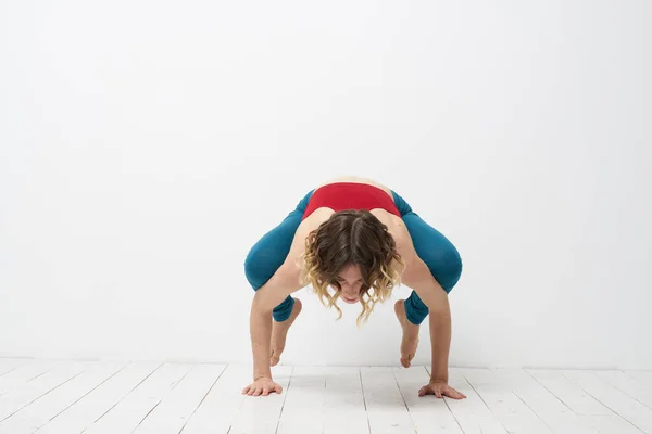 Mujer haciendo yoga de cuerpo entero en interiores polainas azules camiseta roja — Foto de Stock