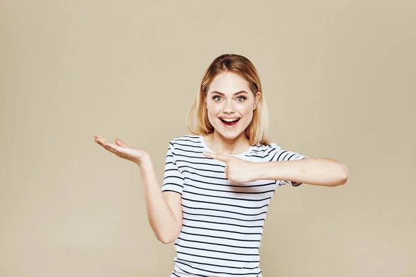Веселая женщина полосатая футболка студии бежевый фон эмоции образа жизни — стоковое фото