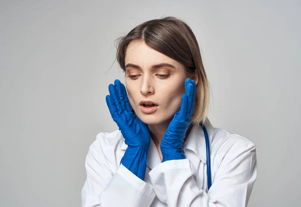 Doctor en guantes médicos azules haciendo gestos con las manos sobre un fondo gris recortado vista — Foto de Stock