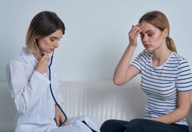 Steteskoplu kadın doktor ve resepsiyondaki hasta.