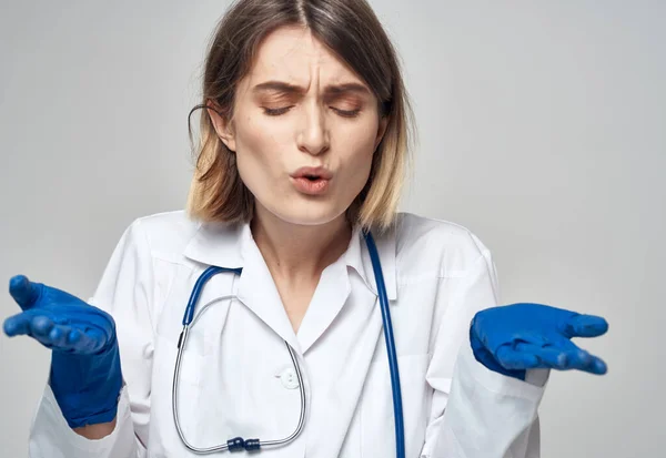 Жінка-лікар в медичній сукні сині рукавички стетоскоп працює медсестрою — стокове фото