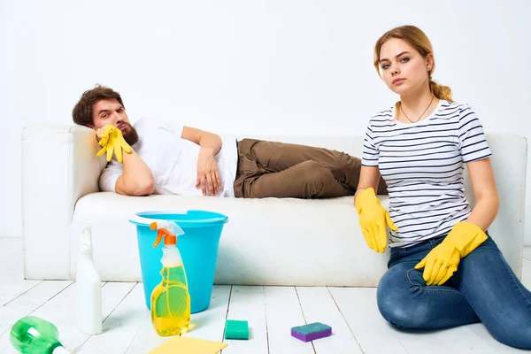 Young couple at home near sofa washing supplies cleaning lifestyle — Stock Photo, Image