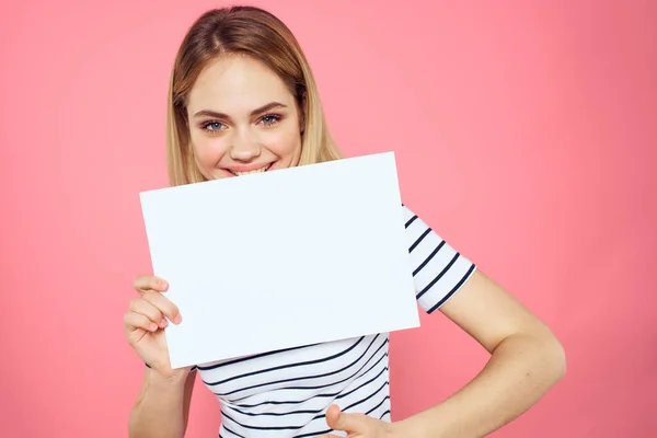 Femme tenant une feuille blanche dans ses mains rayé t-shirt émotions fond rose — Photo