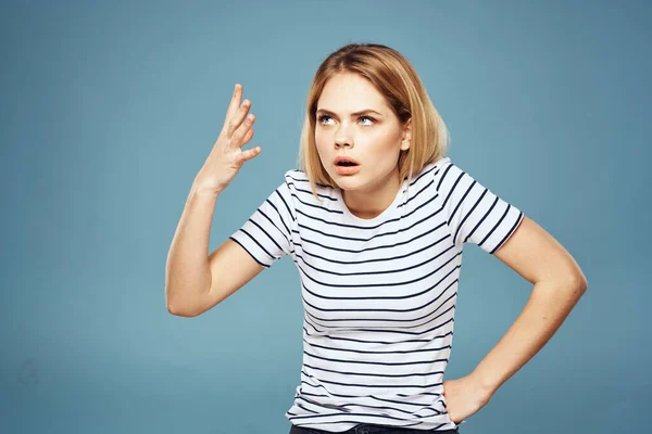 Verärgerte Frau macht Unmutsgesten mit blauem Hintergrund — Stockfoto