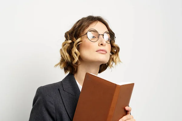 Femme d'affaires dans un costume avec des documents dans les mains fond clair coiffure bouclée — Photo