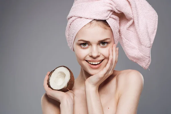 Wanita ceria dengan handuk merah muda di kepalanya perawatan spa kelapa kesehatan kulit bersih — Stok Foto