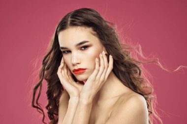 Güzel esmer kadın. Yüzünde pembe arka planda çıplak omuzları olan.