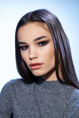 Güzel esmer, parlak makyajlı. Yakından çekici görünüyor.