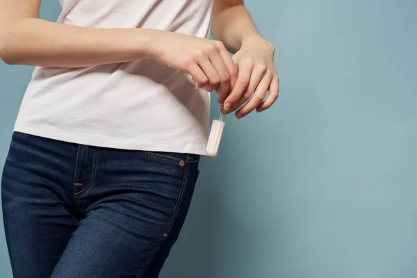 Mujer con tampón y jeans camiseta menstruación fondo azul recortado ver higiene — Foto de Stock
