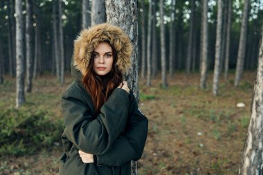 Güz ormanı yolculuğunun arka planında kapüşonlu bir kadın vardı.