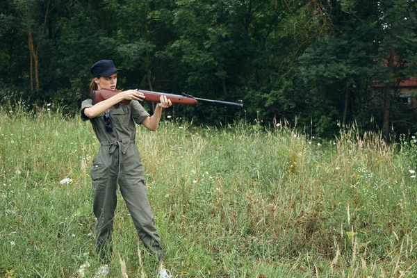 그는 신선 한 공기를 덮는 녹색 사냥에 총을 들고 있는 여자 군인 — 스톡 사진