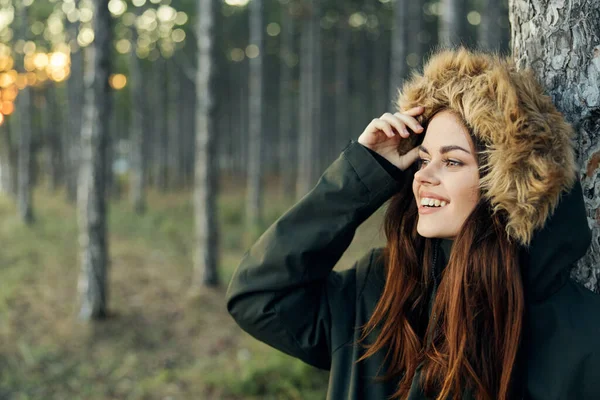 Жінка в лісі в осінній куртці посміхається свіже повітря подорожі — стокове фото