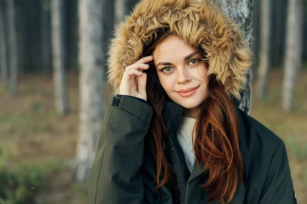 Vrouw in een jas met een kap in de buurt van een boom buiten toerisme frisse lucht — Stockfoto