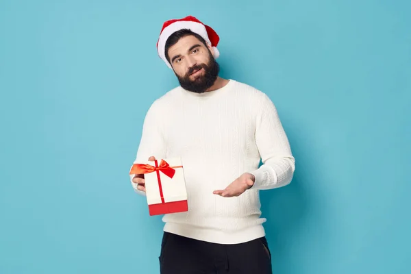Hombre de Navidad en un suéter con una caja de regalo en la mano Año Nuevo — Foto de Stock