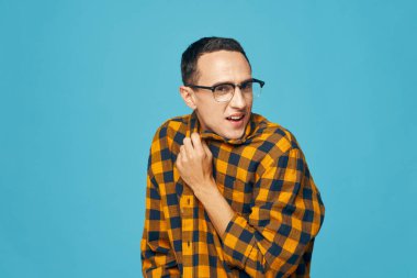  Ekose gömlekli duygusal adam yakasına dokunuyor.