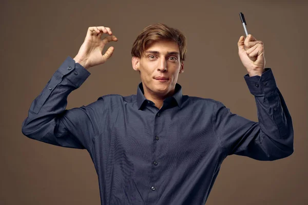 Überraschter Mann mit erhobenen Händen hält einen Stift — Stockfoto