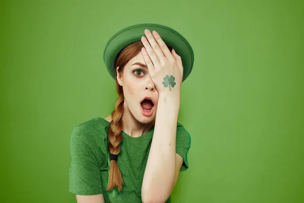 Belle fille avec un trèfle sur sa main sur un fond vert vacances St. Patricks Day chapeau amusant sur sa tête — Photo